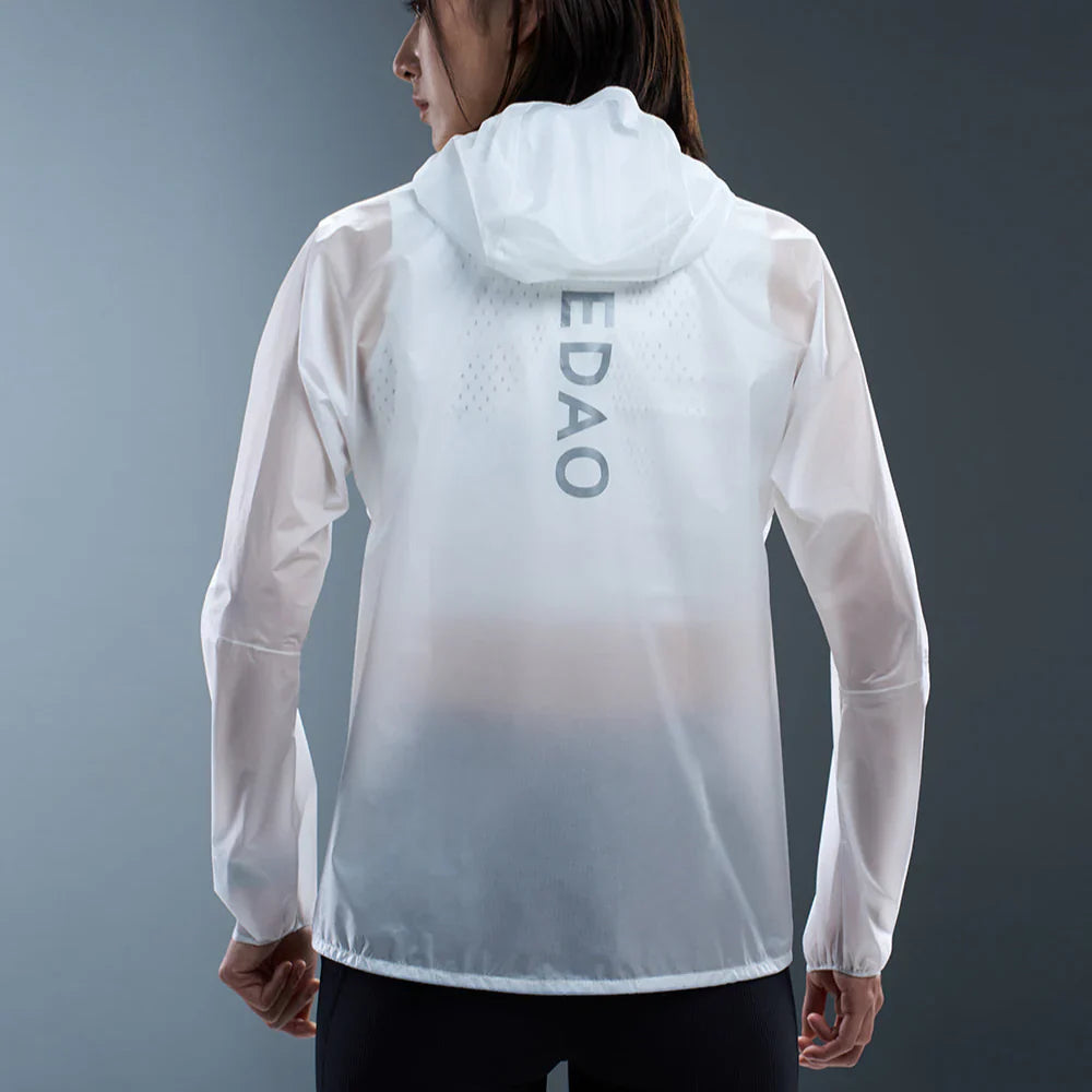 Male runner wearing a black hooded running jacket and shorts, jogging on a rainy day in the city.